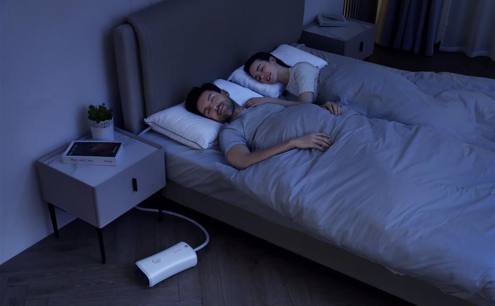 Couple sleeping with the Nitetronic Z6 smart anti-snore pillow system in a nighttime bedroom