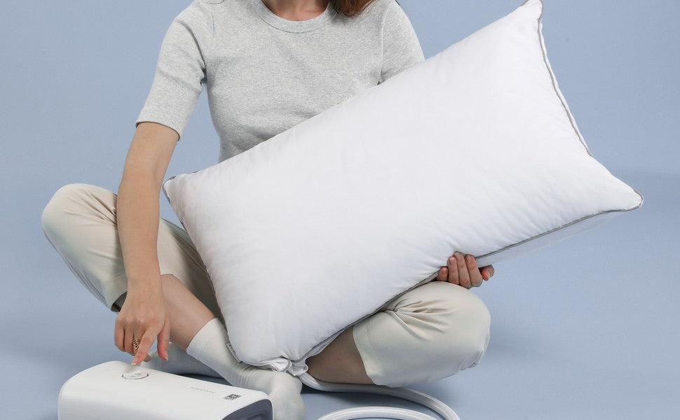 Person holding a Nitetronic Z6 pillow beside its connected controller