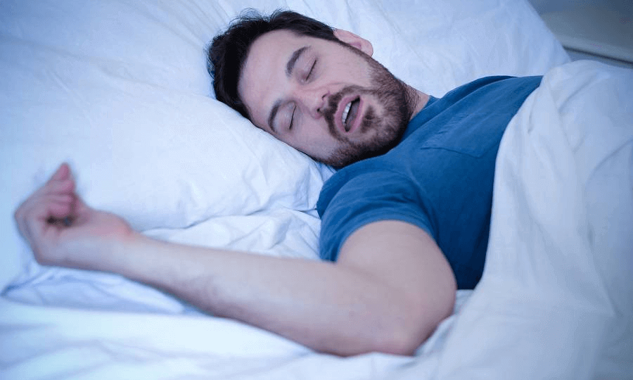 Man sleeping with open mouth, illustrating snoring issues and the need for an effective anti-snore pillow for peaceful rest.