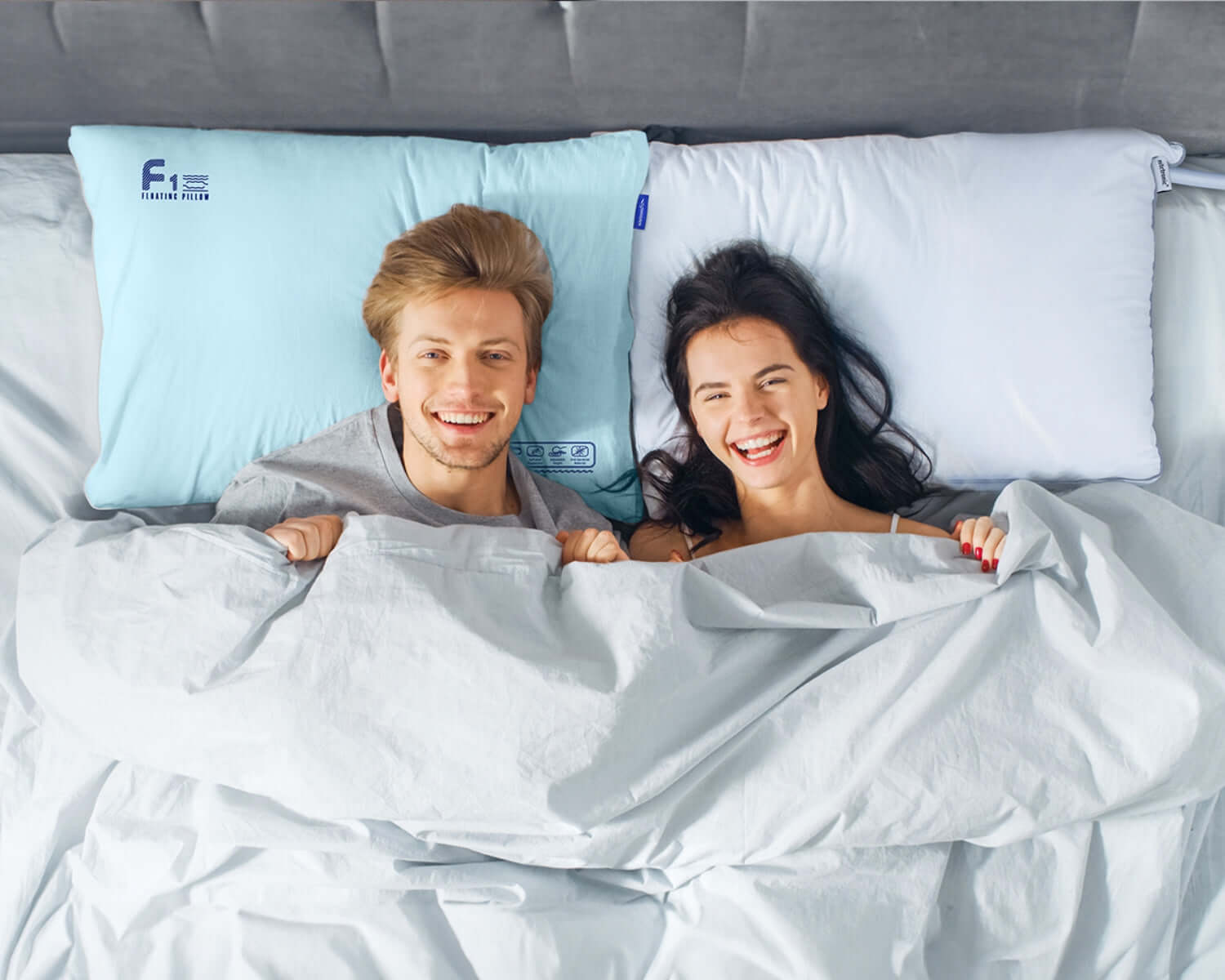 Couple smiling in bed using anti-snore pillows to improve sleep quality and reduce snoring.