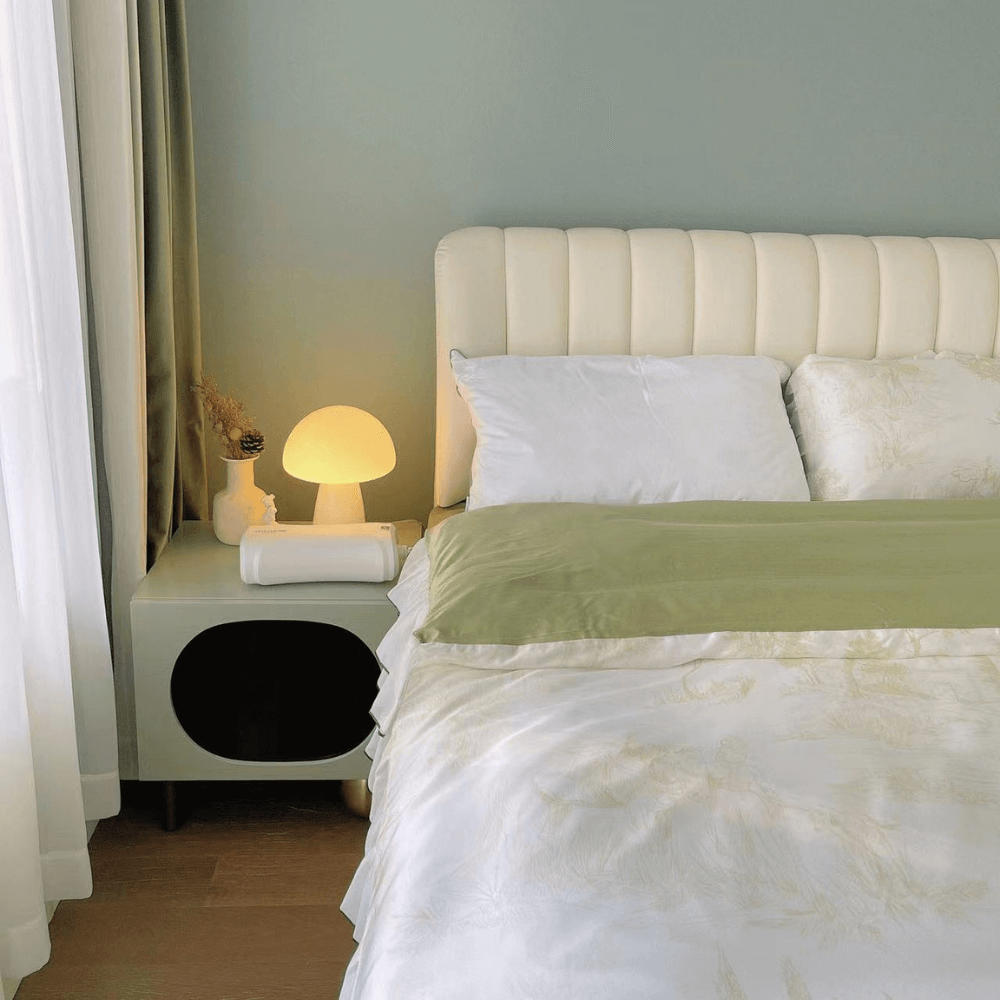 Elegant bedroom with a memory foam pillow on a neatly made bed and a warm bedside lamp, creating a cozy and relaxing atmosphere.