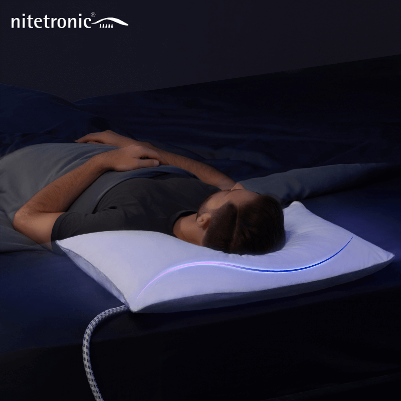 Person sleeping peacefully with an inflatable anti-snore pillow, showing blue LED light feature, promoting restful sleep and snore reduction.