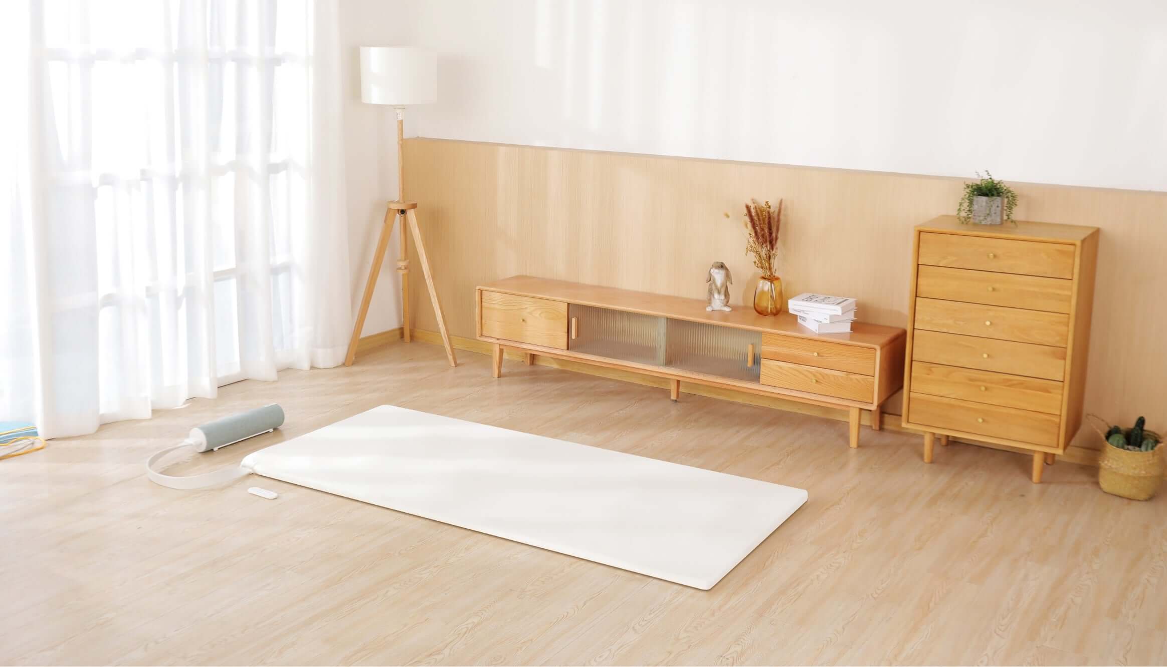Minimalist living room with wooden furniture and a yoga mat for a serene atmosphere.