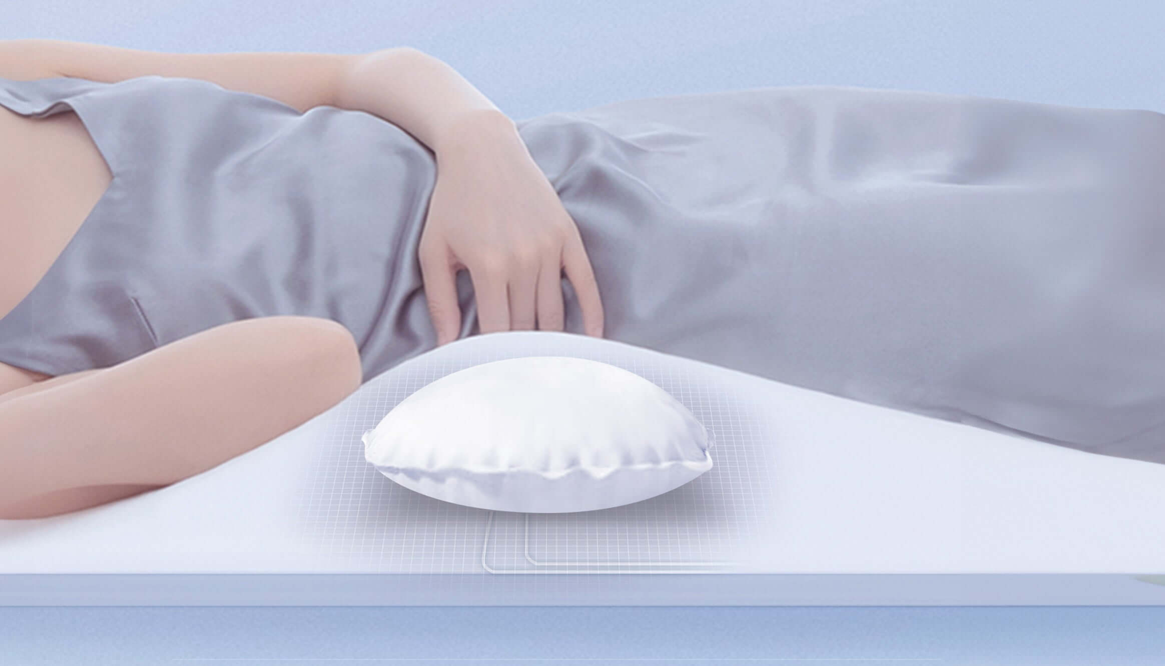 Person in silk sleepwear lying on a white mattress with a white pillow, highlighting comfort and luxury bedding theme.