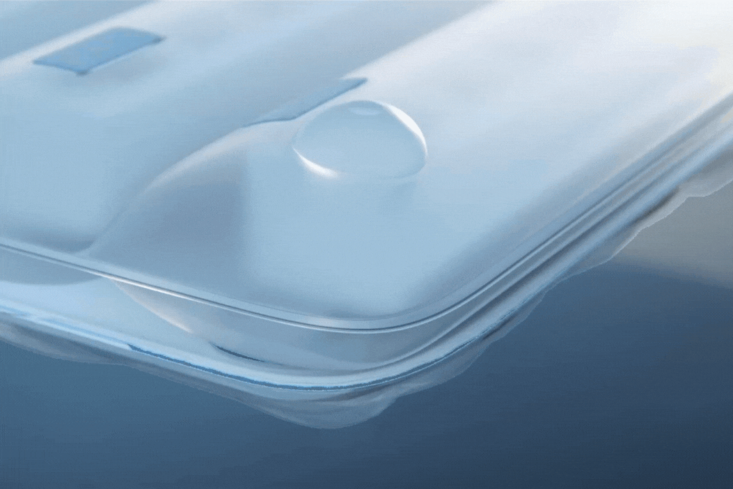 Zoomed view of a smartphone camera lens covered with liquid droplets, showcasing water resistance feature.