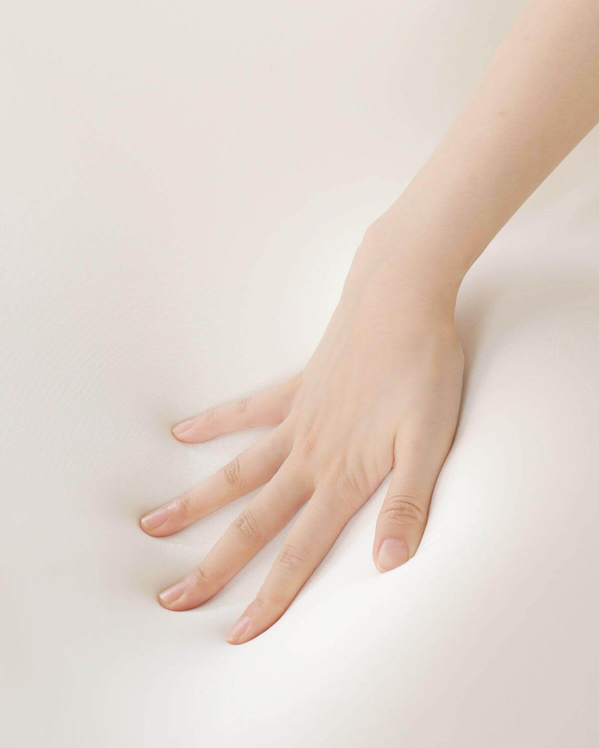 Hand pressing on Nitetronic T3 Pro Smart Mattress Pad showcasing comfort and flexibility.
