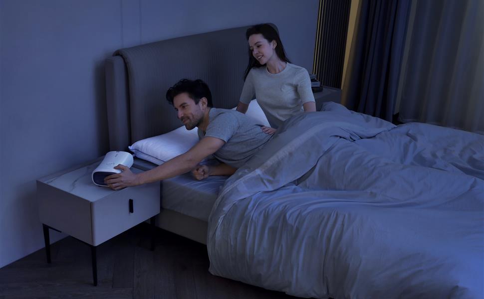 Couple adjusting the Nitetronic Z6 smart anti-snore pillow system during a nighttime sleep routine