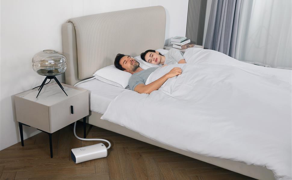 Couple sleeping with a Nitetronic Z6 smart anti-snore pillow in a bedroom