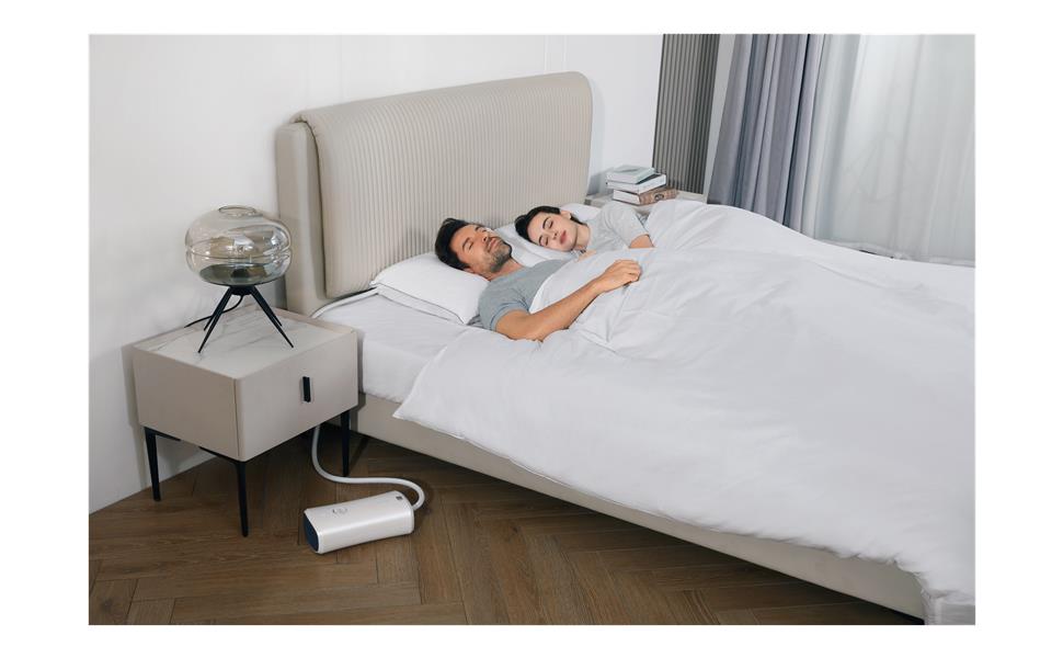 Couple resting with Nitetronic Z6 smart anti-snore pillow system beside the bed