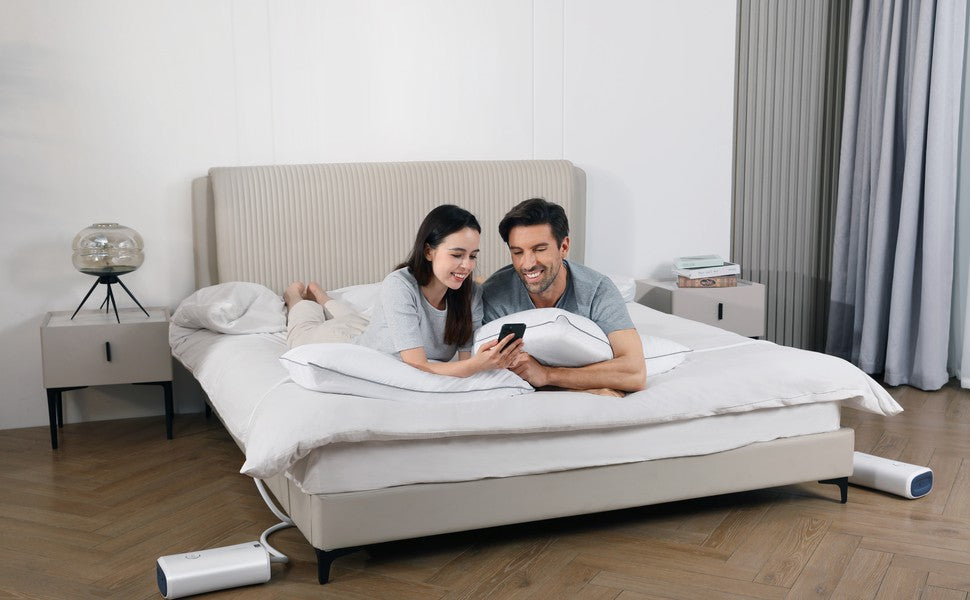 Couple with a Nitetronic Z6 smart pillow and phone on a bed