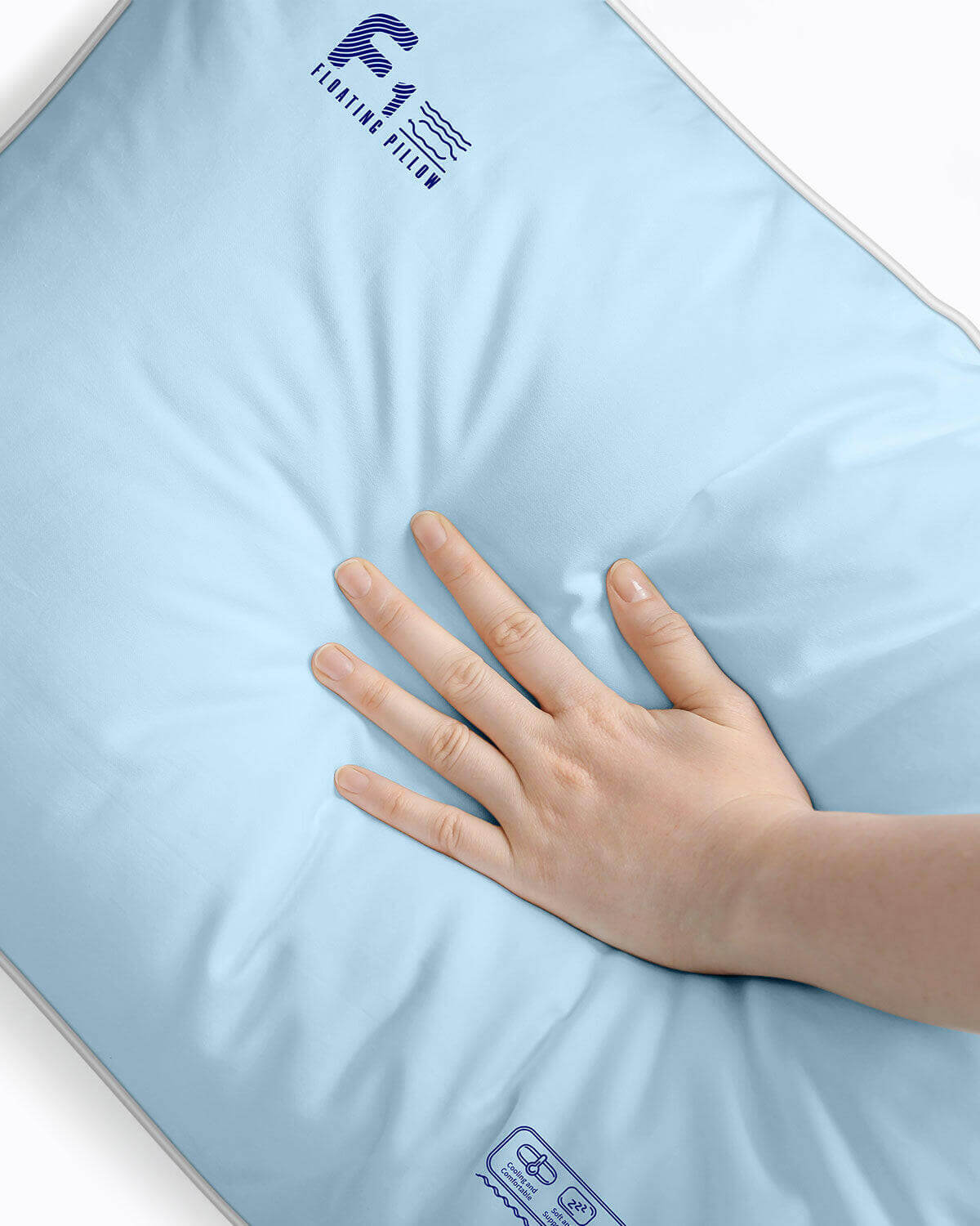 Hand pressing blue Nitetronic F1 Floating Pillow showcasing softness, air-water tech, and adjustable height for optimal neck support.